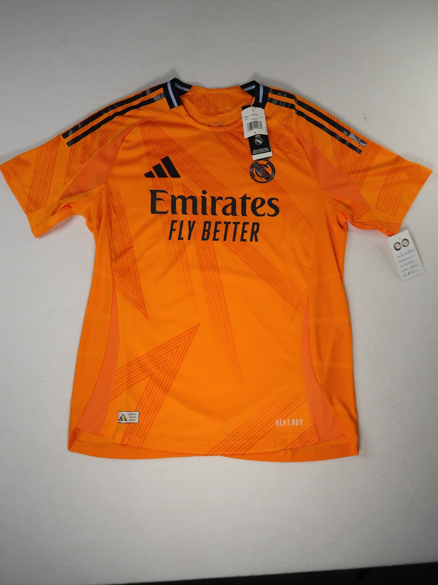 2024-25 Real Madrid away jersey front, orange with Emirates Fly Better sponsor